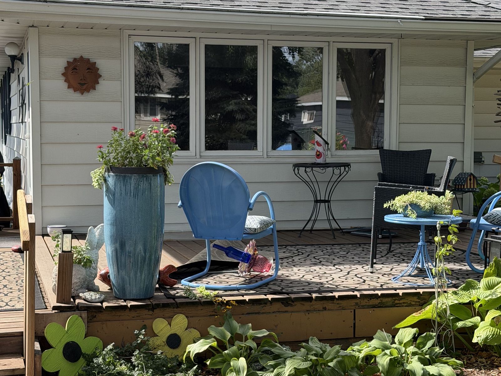 Back patio of a cream rambler with a row of new Windows and light lap Siding