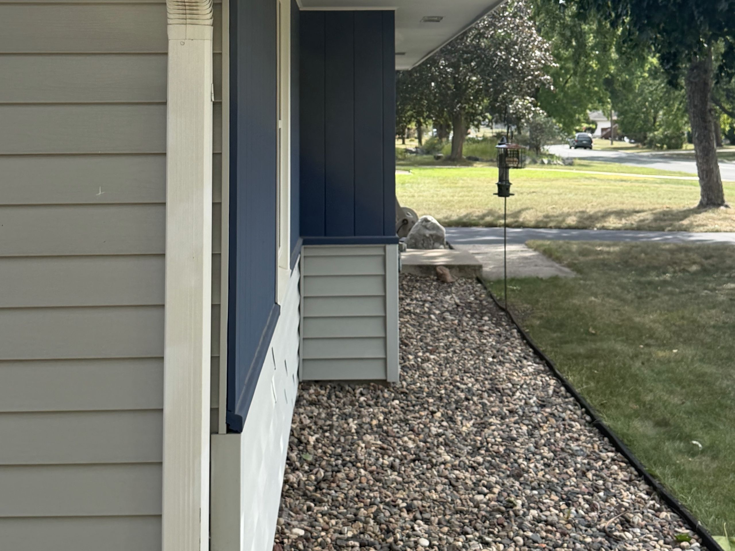Blue board-and-batten and light lap Siding along the side of a rambler