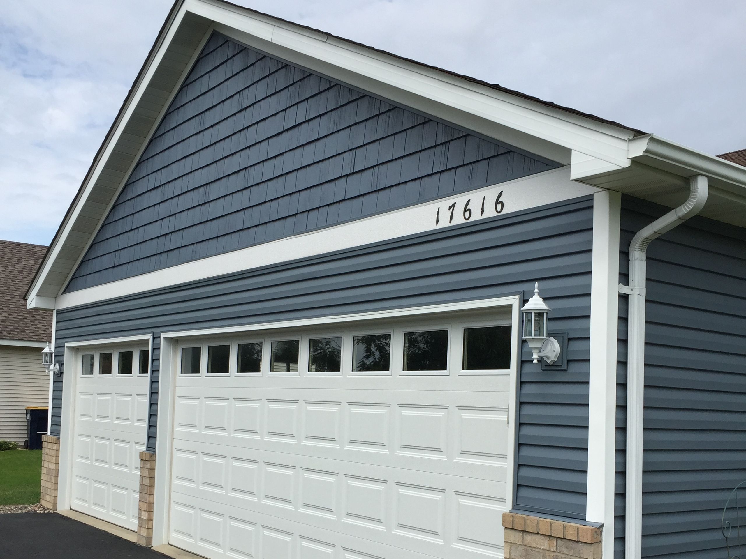 Wrapped Fascia and downspout on a blue-sided house