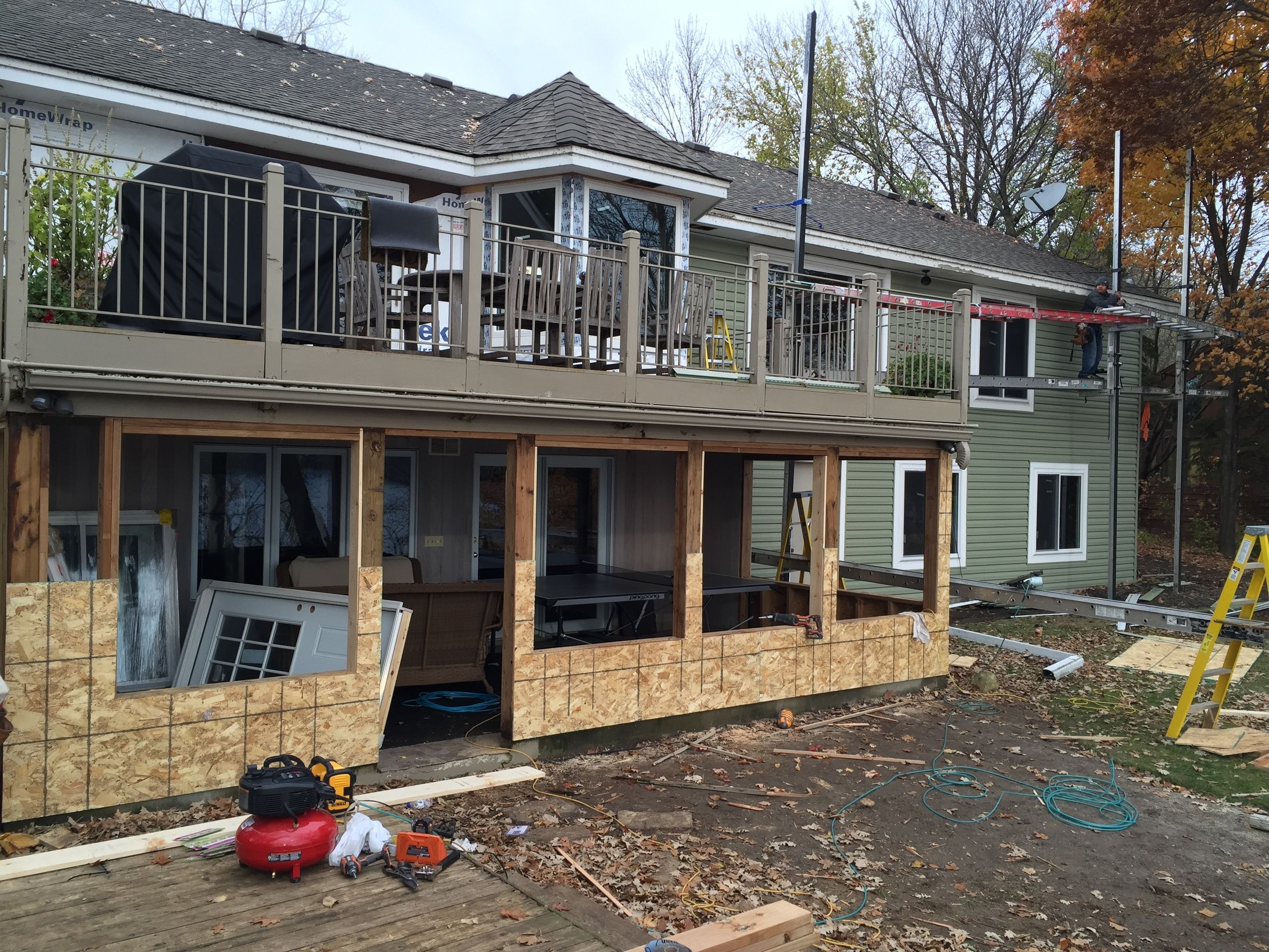 Lake home partway through a re-side, green lap Siding going on and new Windows set