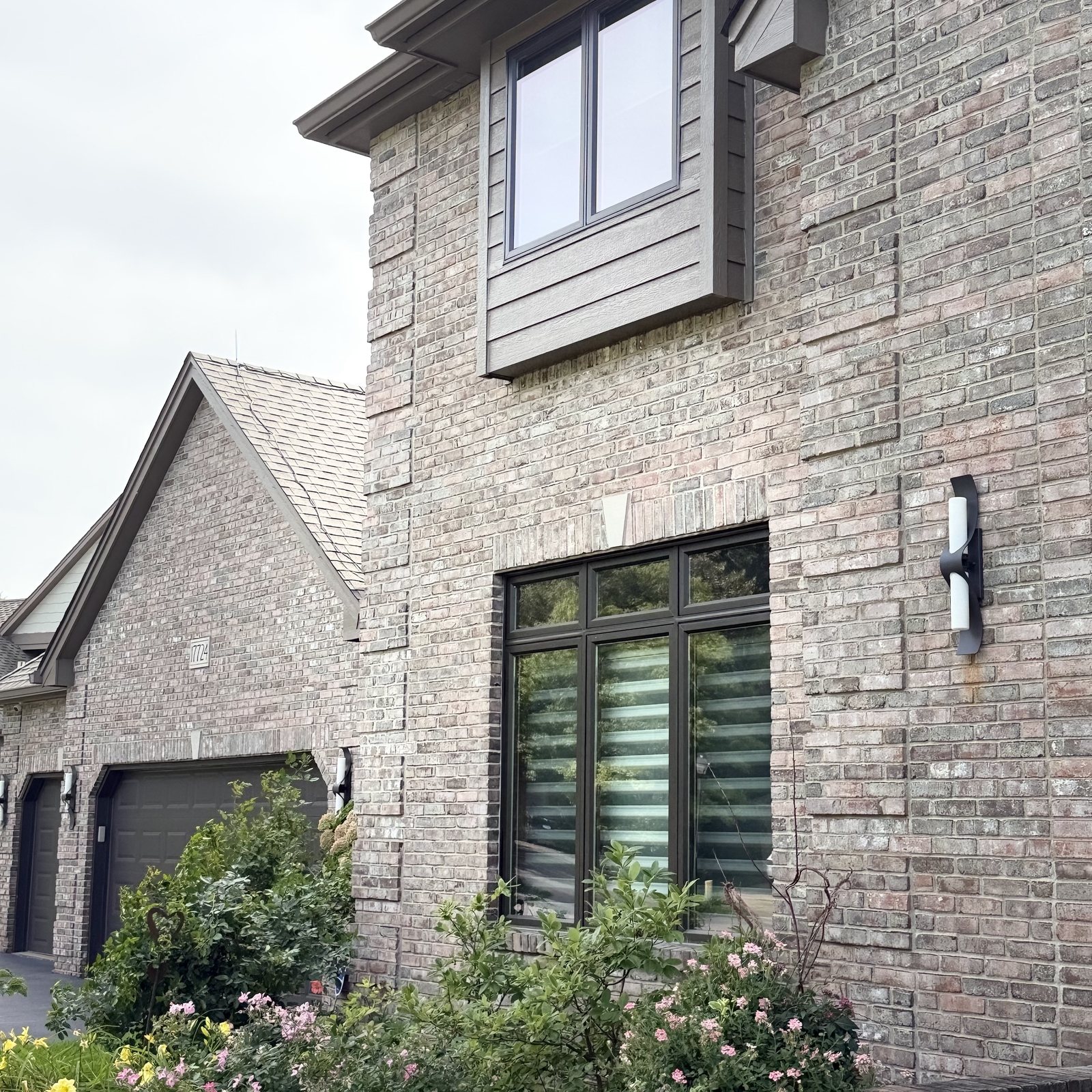Sided bay window above a tall window in a brick wall