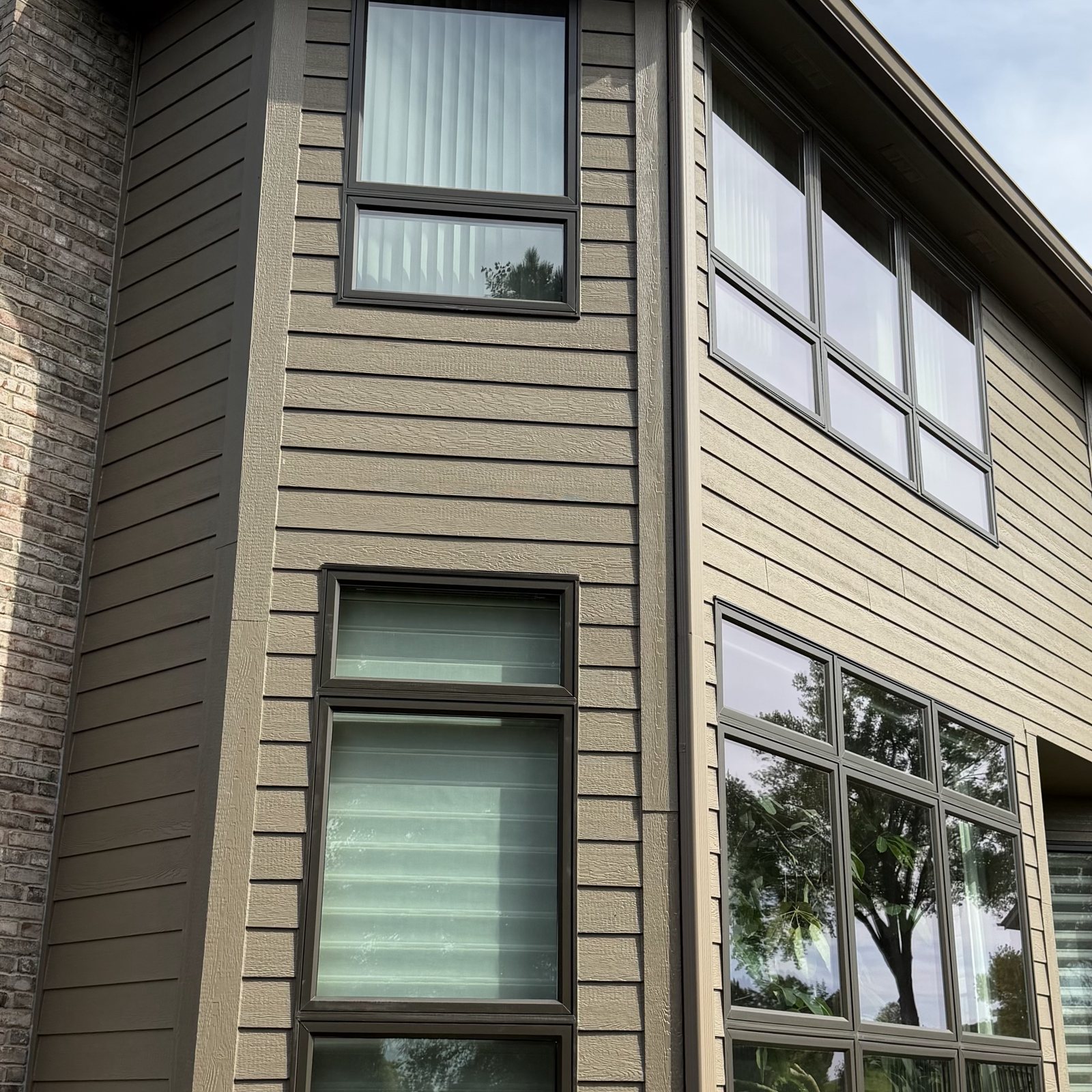 Stacked Windows at the corner of a tan-sided walkout