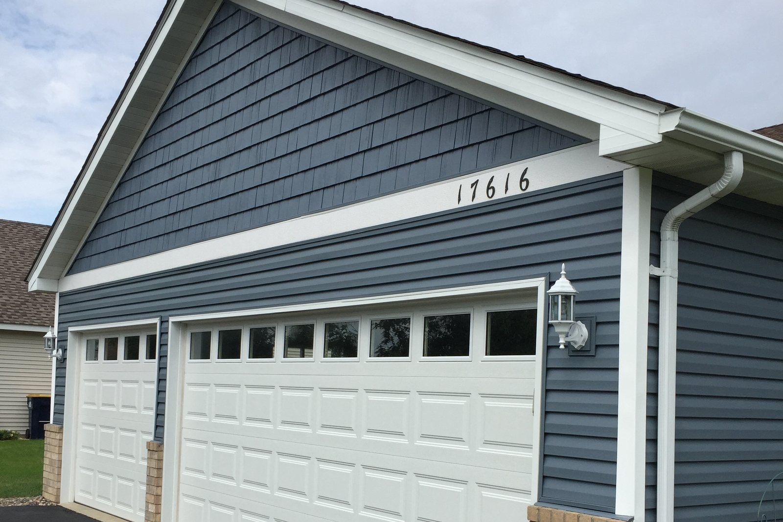Blue vinyl Siding and white trim on a two-car garage