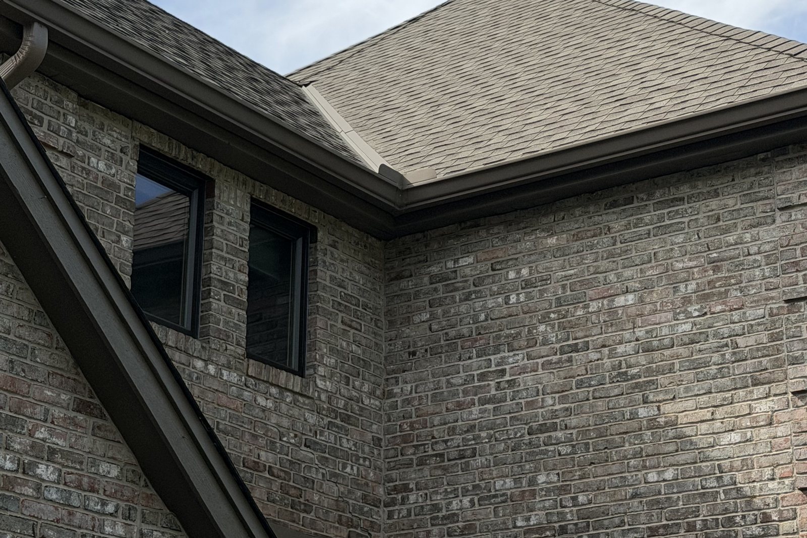 Seamless Gutter running the hip roofline of a brick home