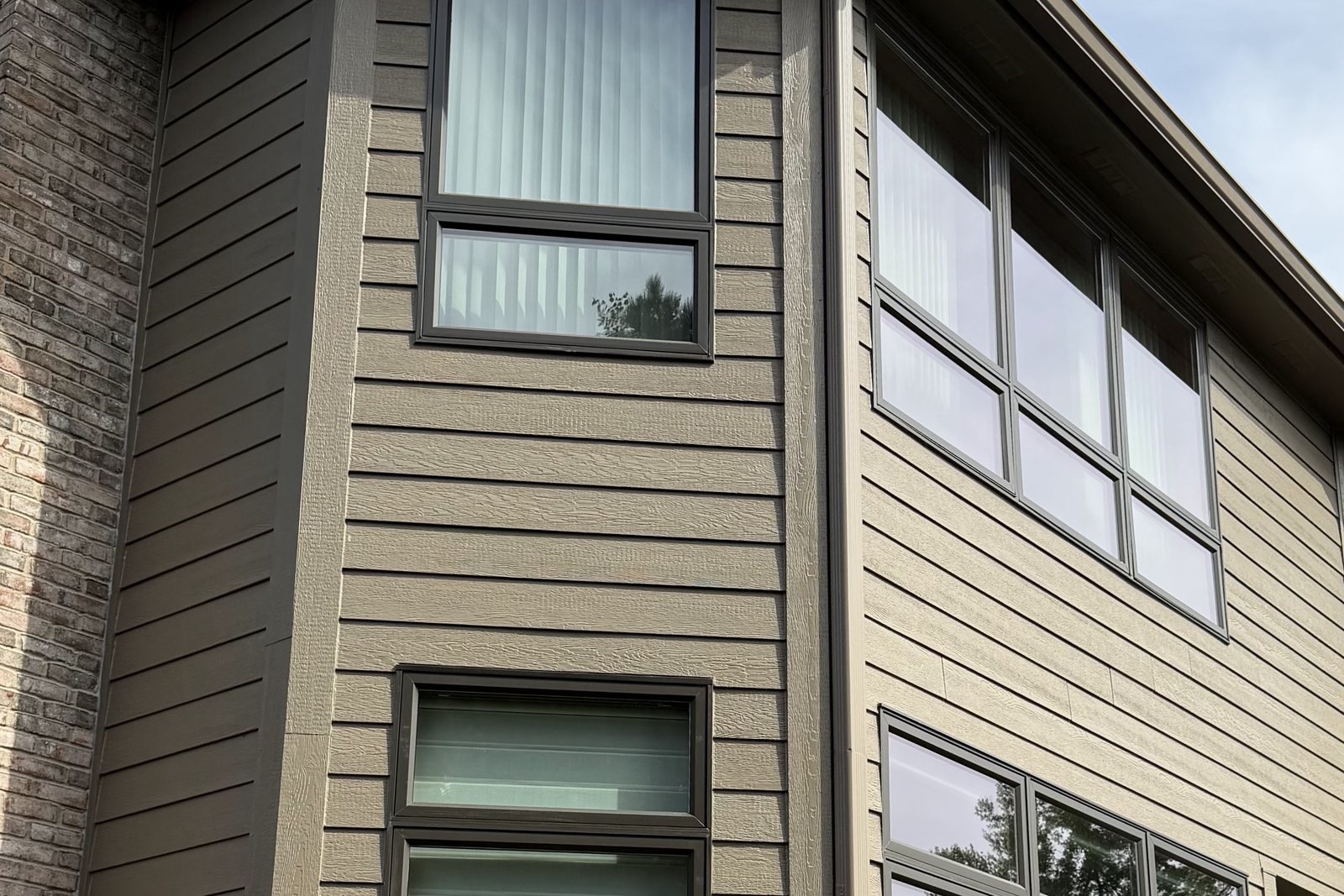 Tan lap Siding with deep shadow lines around a corner bay