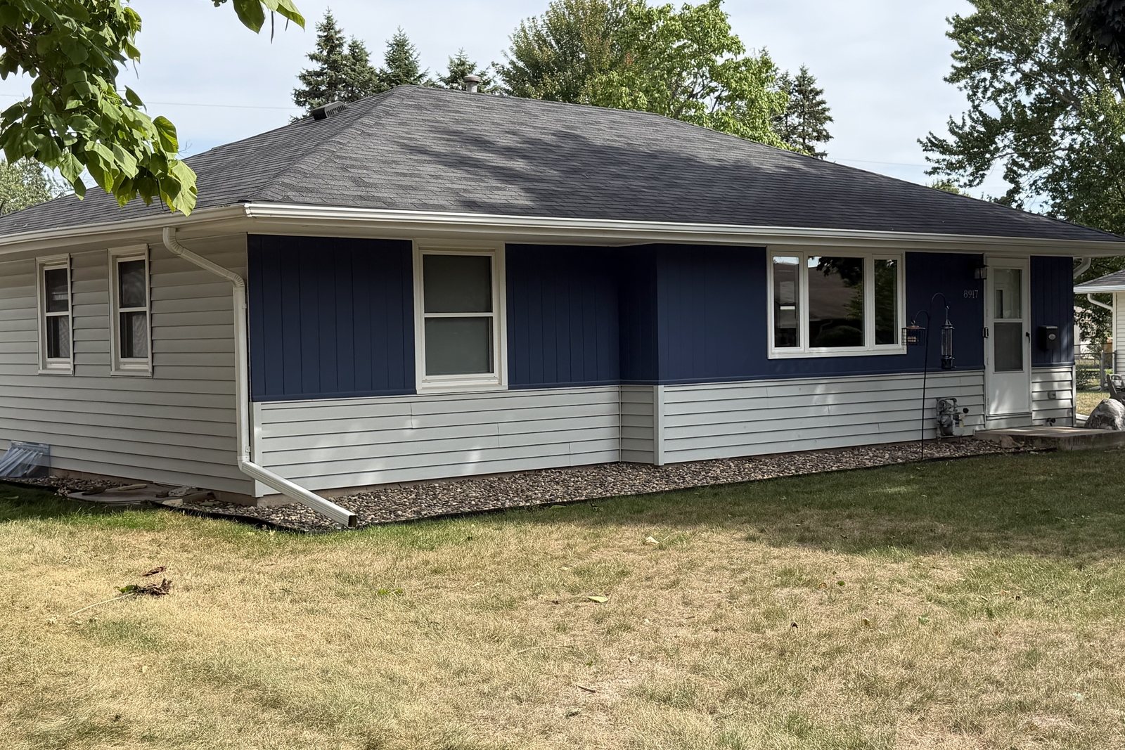 Rambler re-sided with blue vertical boards over white lap Siding