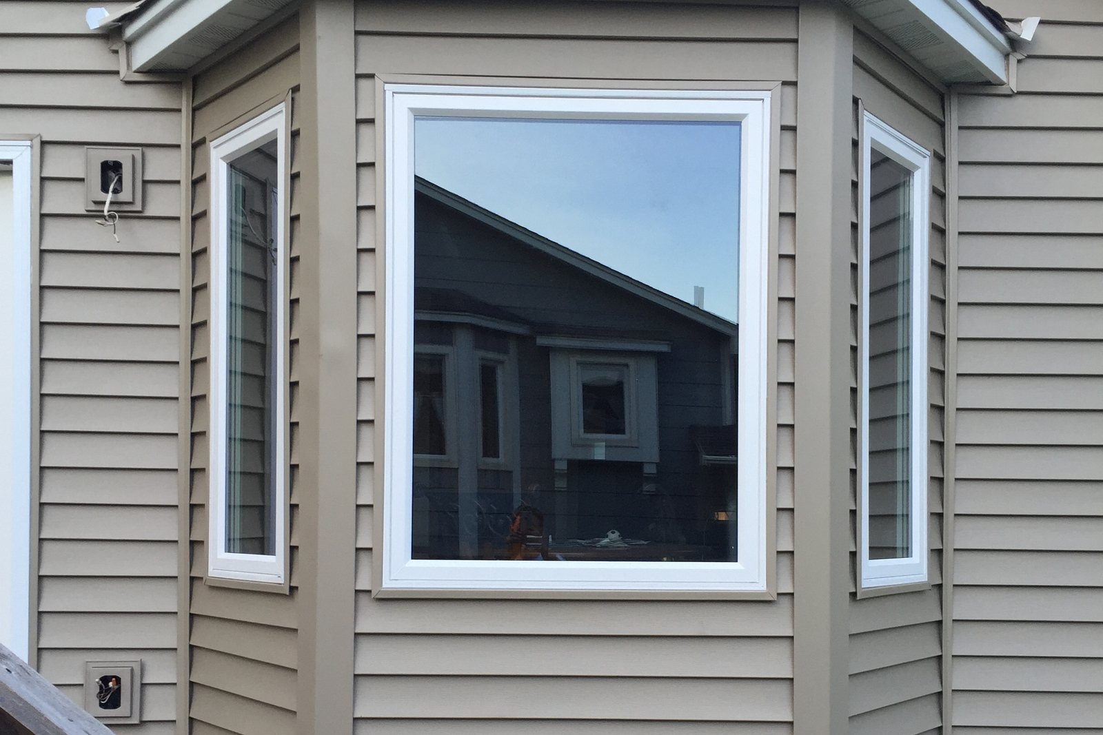 Bay window wrapped in new trim against board and batten Siding